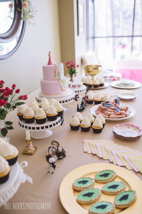 Maleficent Princess Aurora Party Idea. I really adore this party design with a combination of darling cake, hanging crest adorned with floral garland, Maleficent cookies, floral crown and spool of thread cake pops to create a whimsically soft style and floral design flavor. 