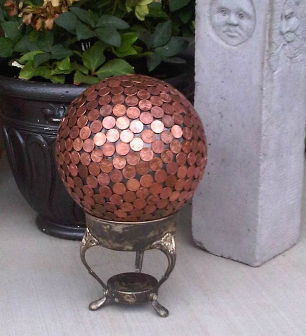 Penny Gazing Ball Yard Art. Add year round color to your garden with fabulous art projects you can make yourself. This gazing ball made with pennies will add more style to your landscape. See how to do it
