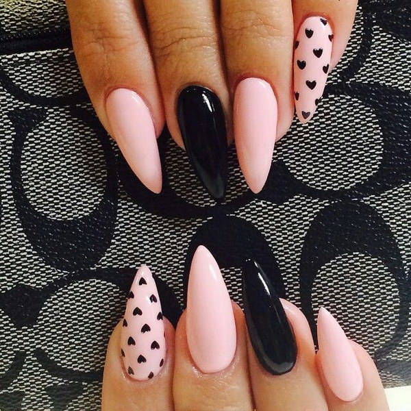 Ongles en forme de stiletto noir et rose avec petit accent de cœur.