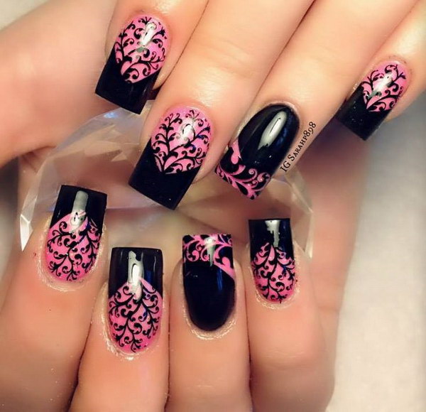 Pointes de chevron noir et détails floraux complexes sur ongles de base rose.