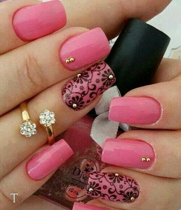 Uñas rosas bonitas con acento de flores negras.