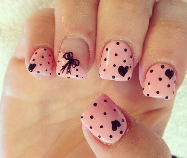 Uñas rosas bonitas con lunares negros, lazos y corazones.