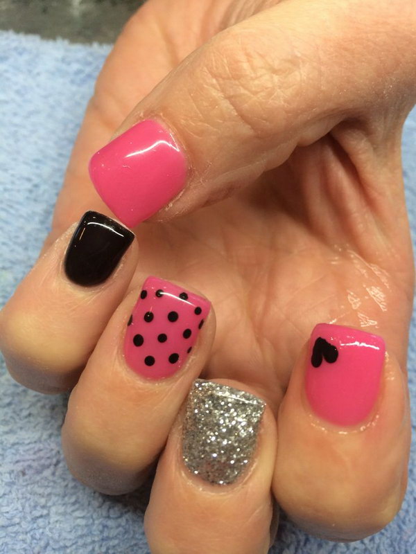 Diseño de uñas rosa y negro con corazones y lunares.