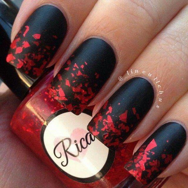 Uñas negras con copos de purpurina roja.