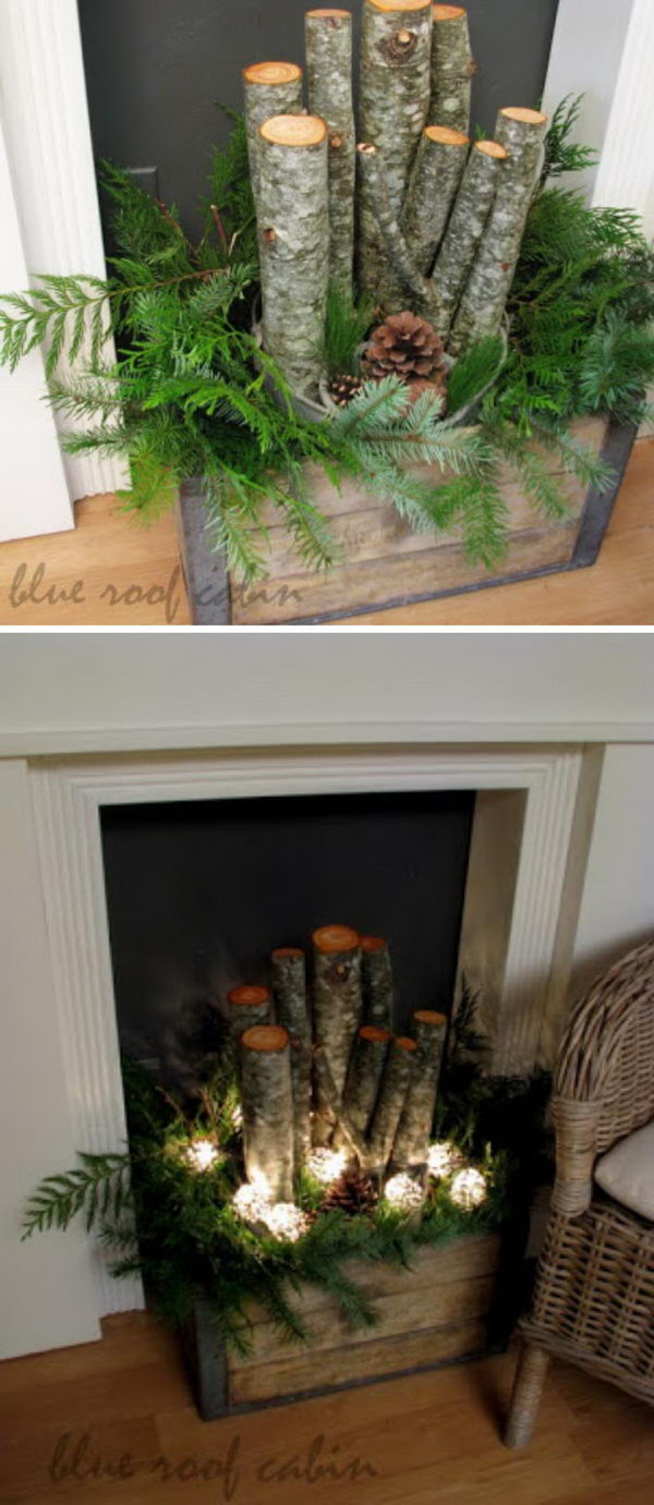 Old Crate Filled With Logs, Greens, Pinecones, And Lights For Christmas. 